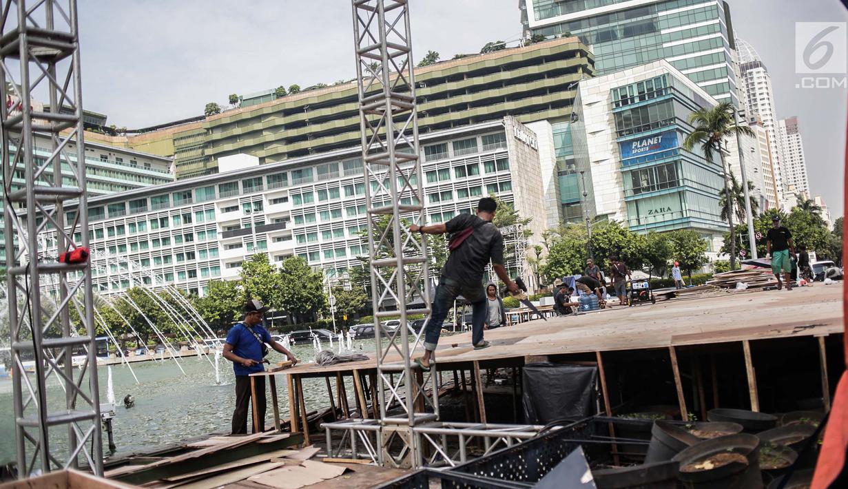 Pekerja menyelesaikan pembuatan panggung HUT ke-492 DKI di area Bundaran HI, Jakarta, Kamis (20/6/2019). Sejumlah artis Ibu Kota akan menghibur dalam peringatan HUT ke-492 DKI Jakarta. (Liputan6.com/Faizal Fanani)