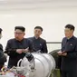 Pemimpin Korut, Kim Jong-un berbincang dengan para peneliti mengenai program senjata nuklir saat meninjau pembuatan bom hidrogen yang dapat dimasukkan ke dalam rudal balistik antarbenua pada 3 September 2017. (AFP Photo/Kcna Via Kns/Str)