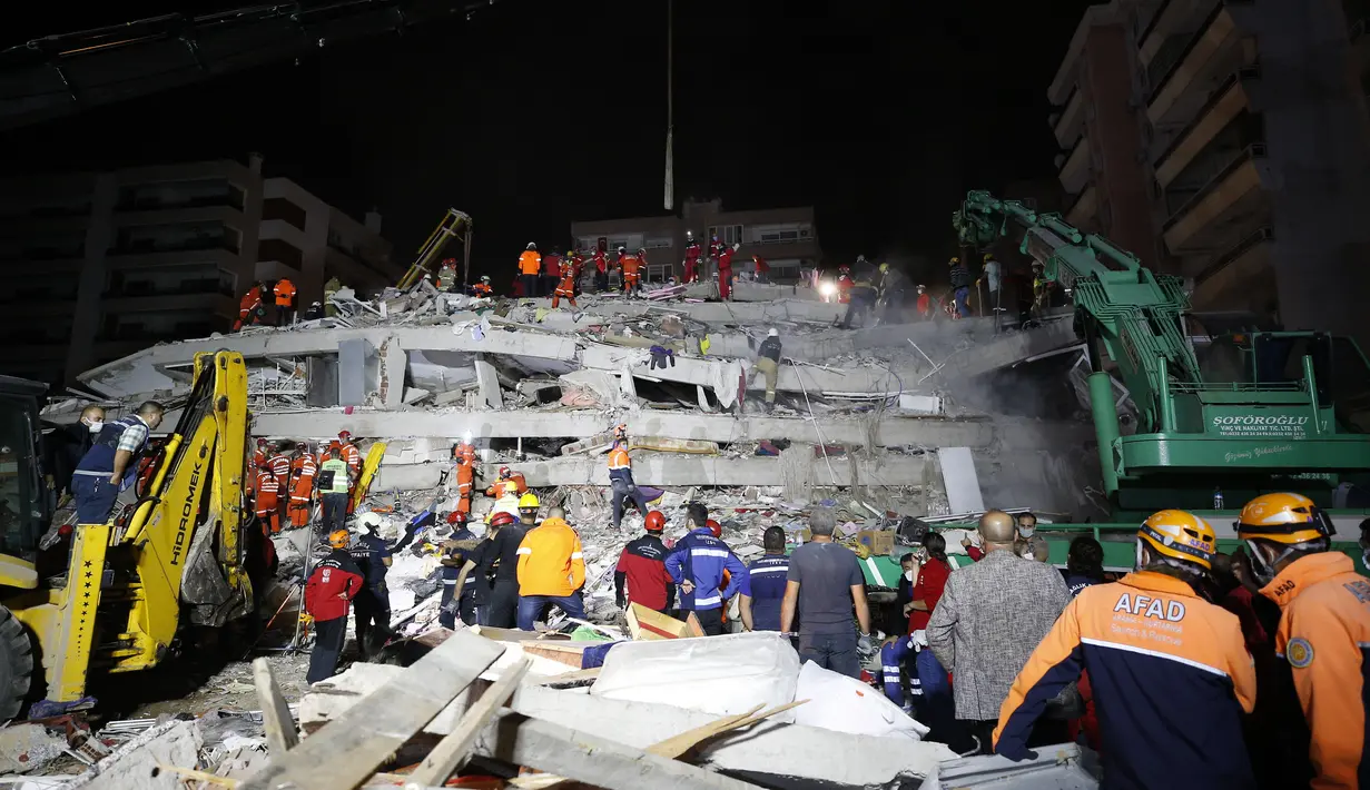 Anggota layanan penyelamatan mencari orang-orang yang selamat di puing-puing bangunan yang runtuh di Izmir, Turki, Sabtu (31/10/2020). Gempa bumi yang kuat melanda pada hari Jumat di Laut Aegea antara pantai Turki dan pulau Samos di Yunani, menewaskan beberapa orang. (AP Photo/Emrah Gurel)