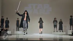 Seorang model membawa ligthsaber seperti yang ada di film Star Wars saat mengenakan busana Populo Batik karya Desainer Bai Soemarlono dan Joseph Lim pada Fashion Show yang di selenggarakan di Senayan City, Jumat Malam, (3/6). (Liputan6.com/Johan Tallo)