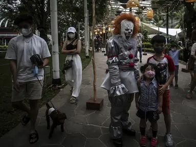 Sejumlah anak berfoto dengan peserta yang mengenakan kostum unik saat Parade Kostum Halloween di Mall Central Park, Jakarta, Sabtu (30/10/2021). Parade Kostum Halloween ini berlangsung pada tanggal 11 sampai 31 Oktober 2021. (Liputan6.com/Johan Tallo)