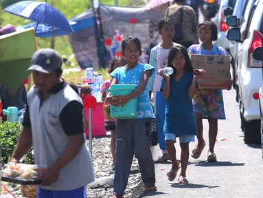 Sejumlah anak berjualan di pintu tol keluar Brebes Timur, Jawa Tengah, (3/7).Mudik lebaran dan libur sekolah di manfaatkan oleh anak-anak yang tinggal di kawasan tersebut untuk berjualan minuman dan makanan. (Liputan6.com/Angga Yuniar)