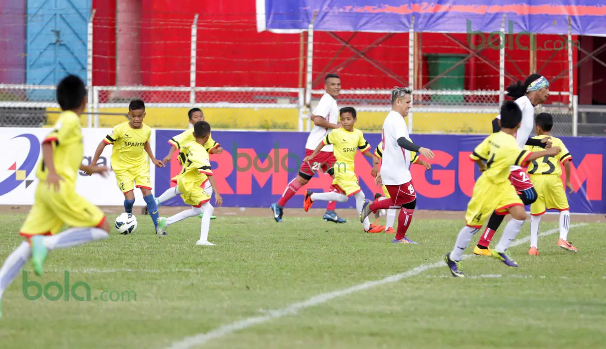 Ratusan Anak-anak SSB kota Padang berlari menyerang ke gawang Legenda Timnas Indonesia pada ajang Irman gusman Cup 2016 diStadion Agus Salim, Padang, Minggu (13/3/2016). (Bola.com/Nicklas Hanoatubun)