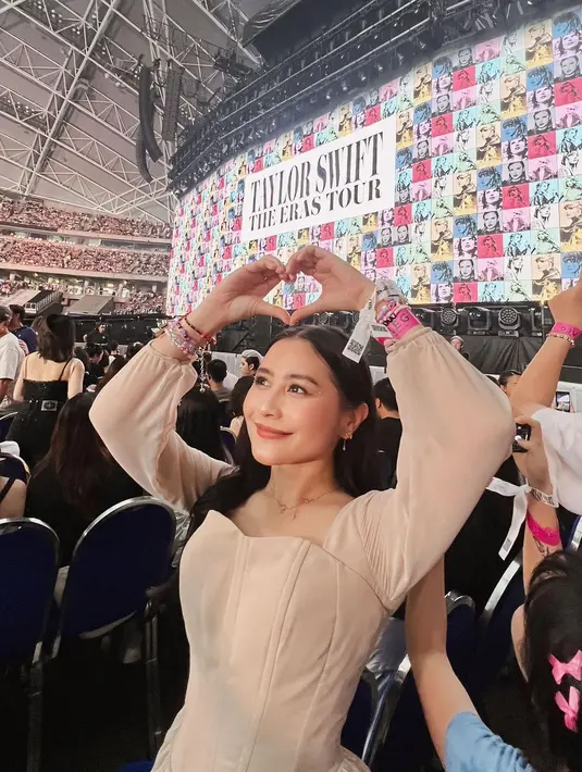 Prilly Latuconsina tampil girly mengenakan dress cokelat muda saat nonton Era's Tour Taylor Swift di Singapura. Dress ini memiliki bentuk hati di bagian dada, lengan panjang, dan dipadukannya mengenakan midi boots bernuansa senada. [Foto: Instagram/prillylatuconsina96]