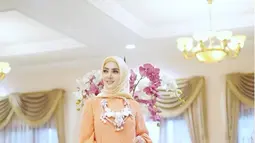 Gaun warna oranye yang sederhana menjadi terlihat fashionable saat dikenakan Syahrini. Tak lupa juga dihiasi dengan kalung cantik. (Liputan6.com/Instagram/@princessyahrini)