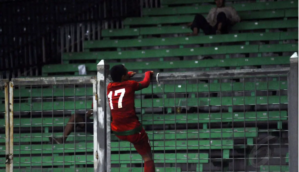 Begitu peluit panjang dibunyikan, Ferdinand Sinaga langsung memanjat pagar pembatas penonton di Stadion GBK Jakarta, (11/5/2014). (Liputan6.com/Helmi Fithriansyah)