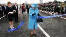 Ratu Inggris Elizabeth II memotong pita dalam peresmian jembatan Queensferry di Skotlandia, Minggu (4/9). Jembatan Queensferry resmi dibuka untuk menghubungkan antar ibu kota Edinburgh dengan bagian utara Skotlandia. (Andrew Milligan/PA via AP)