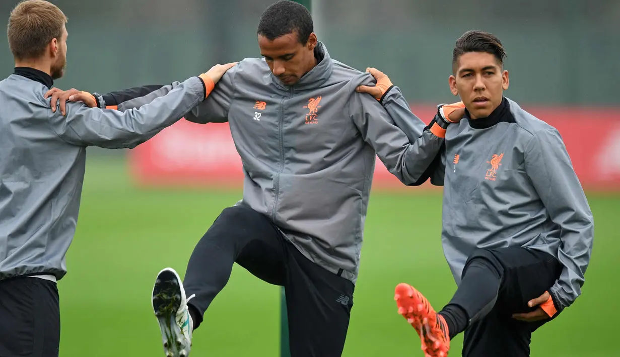 Bek Liverpool, Ragnar Klavan, Joel Matip dan penyerang Roberto Firmino melakukan pemanasan saat latihan di Melwood di Liverpool, Inggris (25/9). Liverpool akan bertanding melawan Spartak Moscow pada Grup E Liga Champions. (AFP Photo/Paul Ellis)