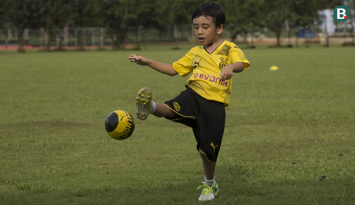 Anak dari Stefano Teco, yang bernama Romario, menendang bola saat latihan Persija Jakarta di Lapangan Sutasoma, Jakarta, Minggu (25/2/2018). Ketika ayahnya bekerja sang anak asyik bermain sepak bola. (Bola.com/Aspirilla Dwi Adha)