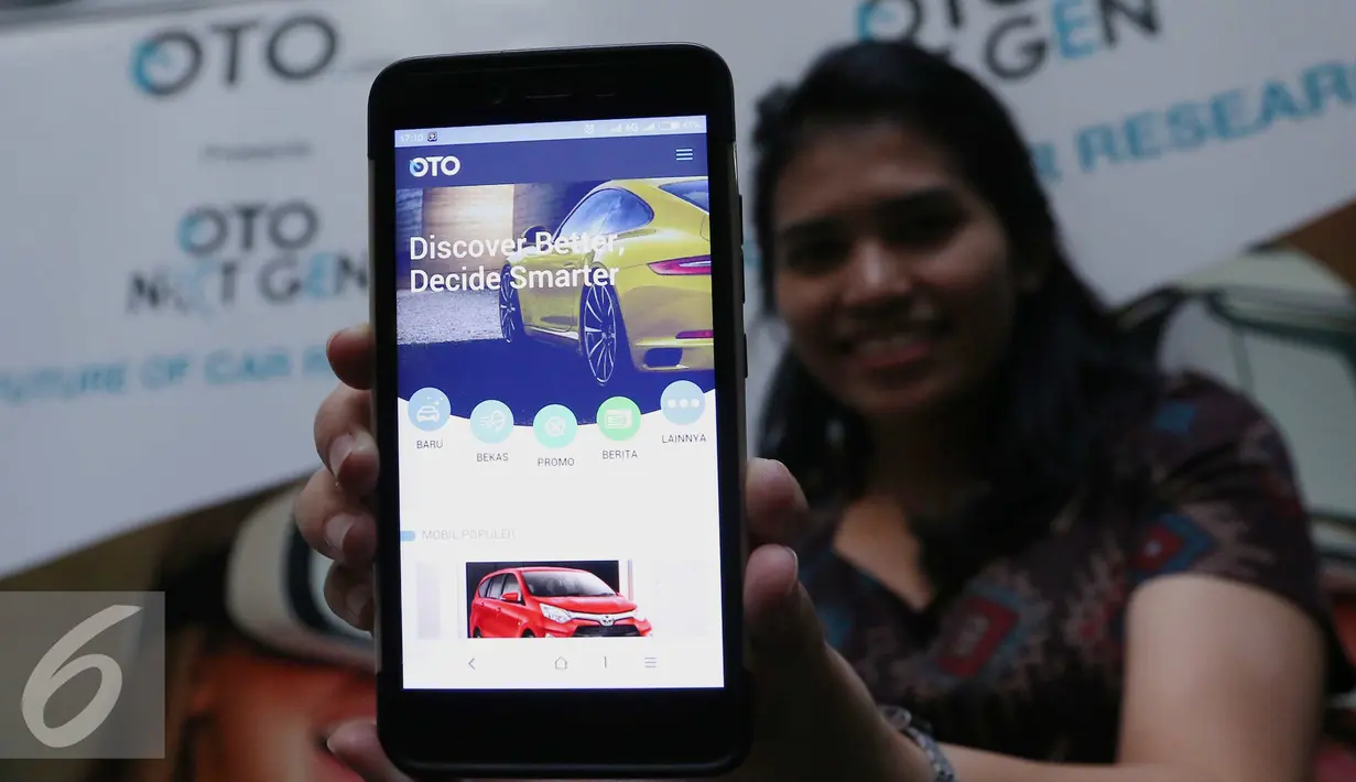 Seorang wanita memperlihatkan tampilan Oto.com dari ponselnya Jakarta, Rabu (28/9). Oto.com hadir dengan sejumlah fitur unggulan yang memudahkan konsumen dalam mencari mobil idaman.  (Liputan6.com/Angga Yuniar)