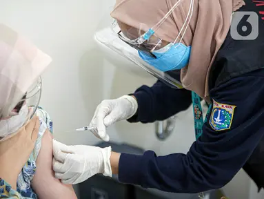 Vaksinator menyuntikkan vaksin COVID-19 dari Pfizer kepada warga di Puskesmas Lebak Bulus, Jakarta, Senin (23/8/2021). Sebanyak 1.560.780 dosis vaksin COVID-19 Pfizer tiba di Indonesia pada 19 Agustus 2021 melalui skema pembelian langsung. (Liputan6.com/Faizal Fanani)