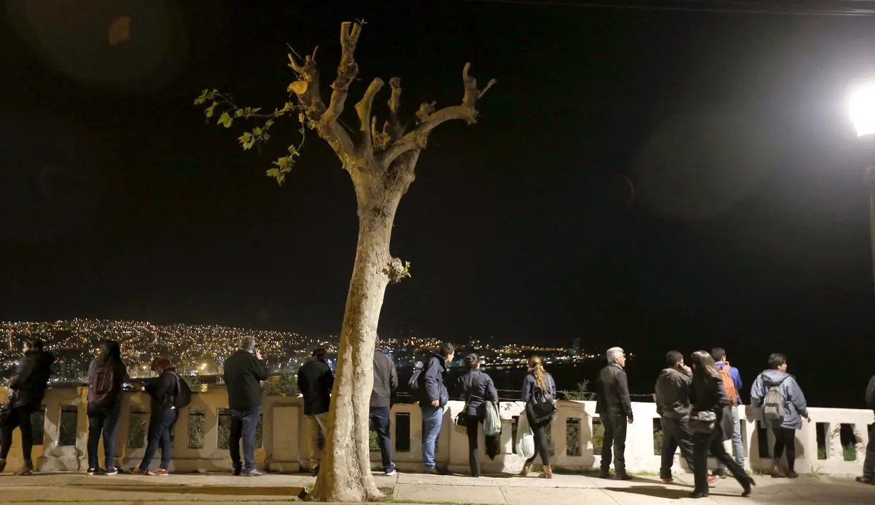 Warga berdiri dan melihat ke laut di Bukit Cerro Barron di kota Valpraiso usai gempa 8,3 SR, Chile, Rabu (16/9).  Menurut laporan dari otoritas setempat, gempa itu berpotensi memicu tsunami yang akan melanda Chile dan Peru.  (REUTERS/Rodrigo Garrido)
