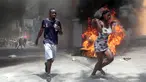 Demonstran berlari melewati ban yang dibakar selama protes terhadap ketidakamanan di Port-au-Prince, Haiti, Senin (7/8/2023). Ribuan warga Haiti turun ke jalan-jalan Port-au-Prince untuk memprotes kurangnya keamanan. (AP Photo/Odelyn Joseph)