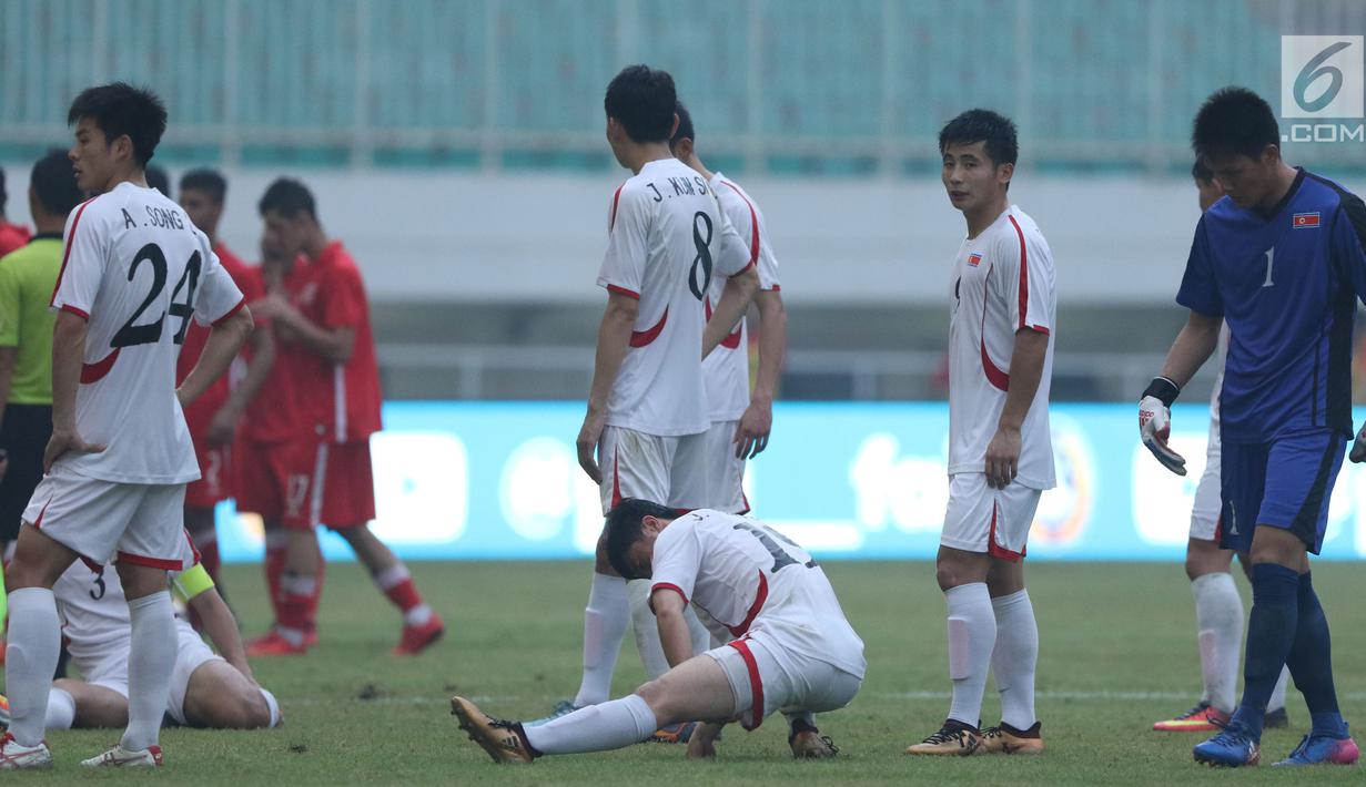 Pemain Korea Utara berkumpul saat laga melawan Bahrain dihentikan sementara akibat lampu mati pada  PSSI Anniversary Cup 2018 di Stadion Pakansari, Kab Bogor, Kamis (3/5). Laga dimenangkan Bahrain 4-1. (Liputan6.com/Helmi Fithriansyah)