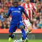 Gelandang Chelsea, N'Golo Kante (depan) berusaha membawa bola dari kejaran pemain Stoke City pada lanjutan Liga Inggris di Stadion Bet365 di Stoke-on-Trent, (23/9). Chelsea menang 4-0 atas Stoke. (AFP Photo/Lindsey Parnaby)