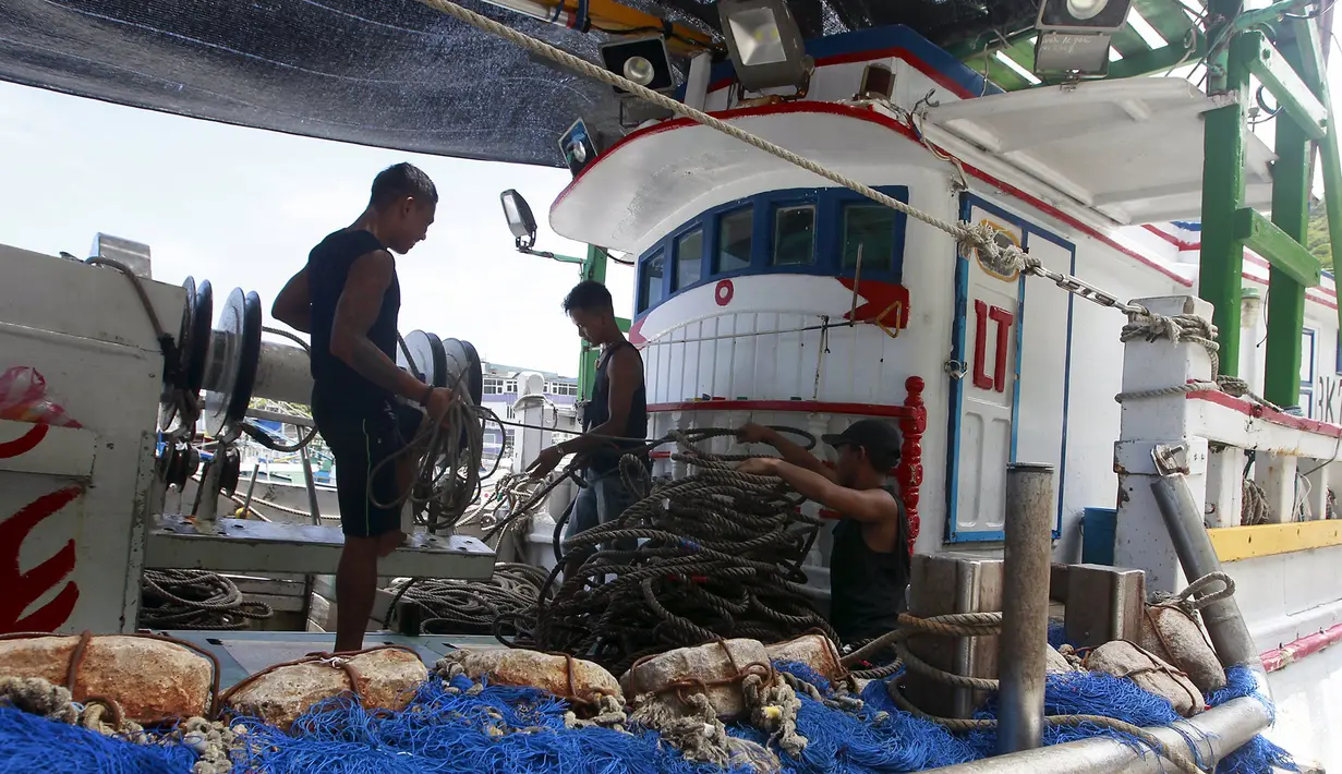Sejumlah Nelayan mengatur tali di dalam perahu akibat badai Topan Chan-hom yang mendekati wilayah pesisir timur laut Nanfangao di Ilan County, Taiwan Utara, (9/7/2015). Akibat Topan Chan-hom para nelayan berhenti melaut sementara. (REUTERS/Pichi Chuang)