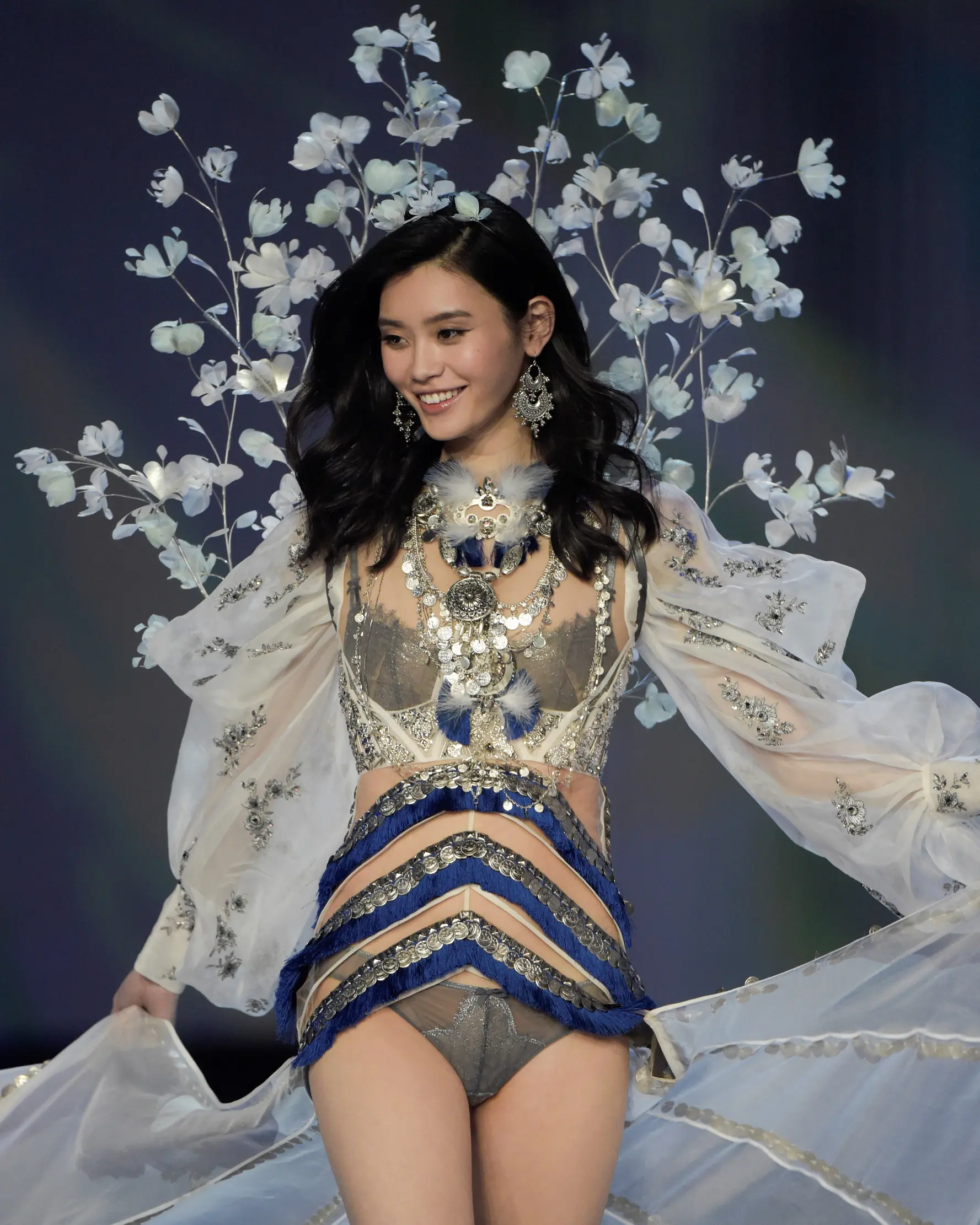Model Tiongkok, Ming Xi berjalan di atas catwalk memperagakan koleksi lingerie pada Victoria’s Secret Fashion Show 2017 di Shanghai, Senin (20/11). Ming sempat tergelincir dan jatuh tersungkur di catwalk. (FRED DUFOUR/AFP)