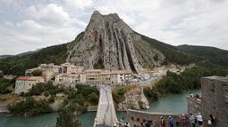 Pebalap Tour de France melewati kota Sisteron dengan bukit yang unik pada etape ke-29 dengan jarak tempuh 222,5 km dari Embrun menuju Salon-de-Provence, Prancis, (21/7/2017). (AP/Christophe Ena)