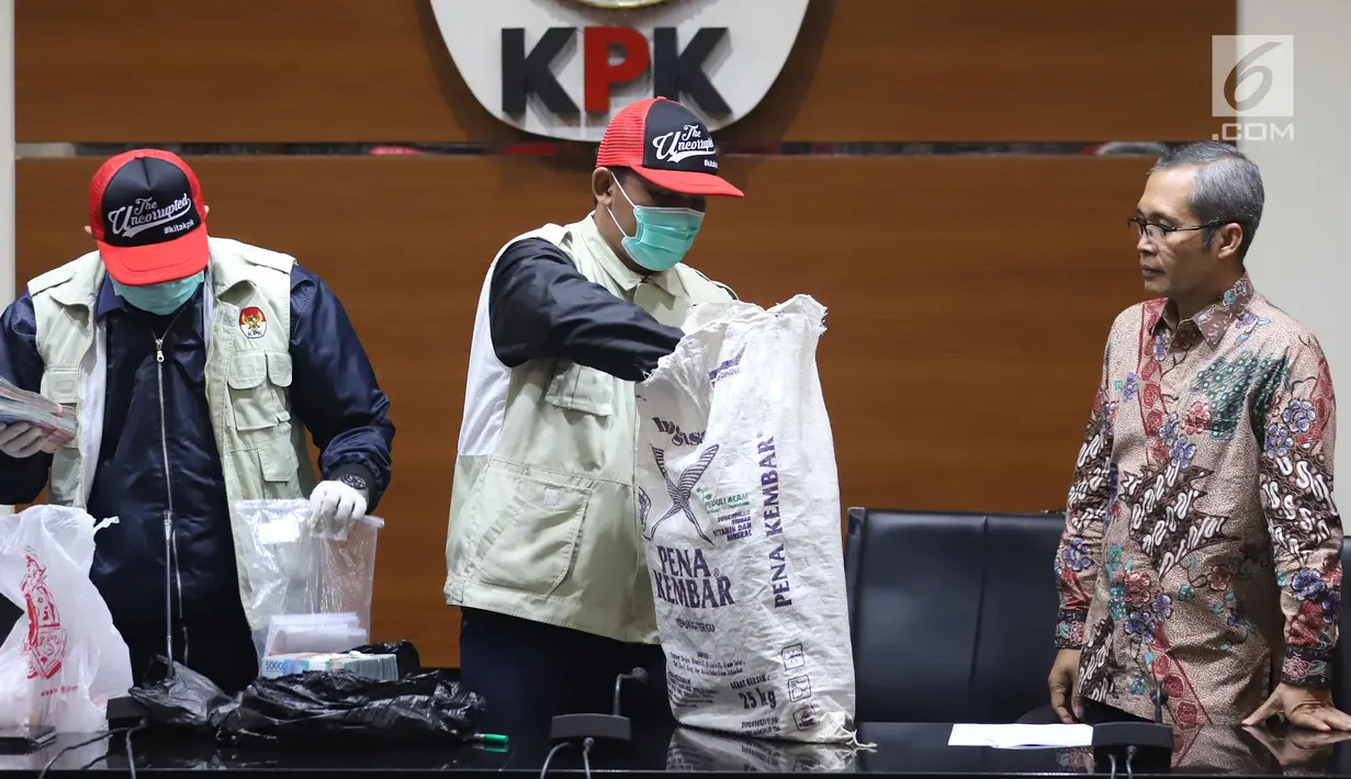 Petugas KPK mengambil barang bukti uang saat jumpa pers terkait OTT Bupati Cirebon Sunjaya Purwadi Sastra di Jakarta, Kamis (25/10). Selain jual beli jabatan, Sunjaya juga menjadi tersangka atas proyek dan perizinan. (Liputan6.com/Herman Zakharia)
