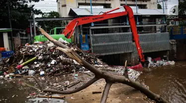 Alat berat beroperasi mengangkut sampah yang menumpuk di Pintu Air Manggarai, Jakarta, Selasa (4/12). Tingginya intensitas hujan di wilayah Jabodetabek membuat sampah yang terbawa arus sungai menumpuk di Pintu Air Manggarai. (Liputan6.com/Faizal Fanani)