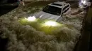Sebuah mobil berusaha menerjang banjir yang merendam jalanan di Brooklyn, New York, Amerika Serikat, Kamis (2/9/2021). Pemerintah setempat sampai mengumumkan status darurat banjir bandang, suatu peringatan yang jarang sekali dikeluarkan. (AFP/Ed Jones)