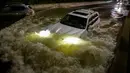 Sebuah mobil berusaha menerjang banjir yang merendam jalanan di Brooklyn, New York, Amerika Serikat, Kamis (2/9/2021). Pemerintah setempat sampai mengumumkan status darurat banjir bandang, suatu peringatan yang jarang sekali dikeluarkan. (AFP/Ed Jones)