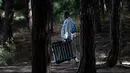 Seorang pria yang memakai masker wajah berjalan di antara pepohonan di pantai Sa Conca di Castell-Platja D'Aro dekat Girona, Spanyol pada Rabu (31/3/2021). Spanyol termasuk negara yang parah terhantam pandemi covid-19 dengan lebih dari 75 ribu kematian dari hampir 3,3 juta kasus. (Josep LAGO / AFP)