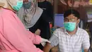 Tenaga kesehatan menjalani pemeriksaan sebelum menjalani vaksinasi COVID-19 di Puskesmas Jurang Mangu, Tangerang Selatan, Jumat (15/1/2021). Program vaksinasi COVID-19 tahap pertama kepada tenaga kesehatan mulai dilakukan di berbagai daerah di Indonesia. (Liputan6.com/Angga Yuniar)