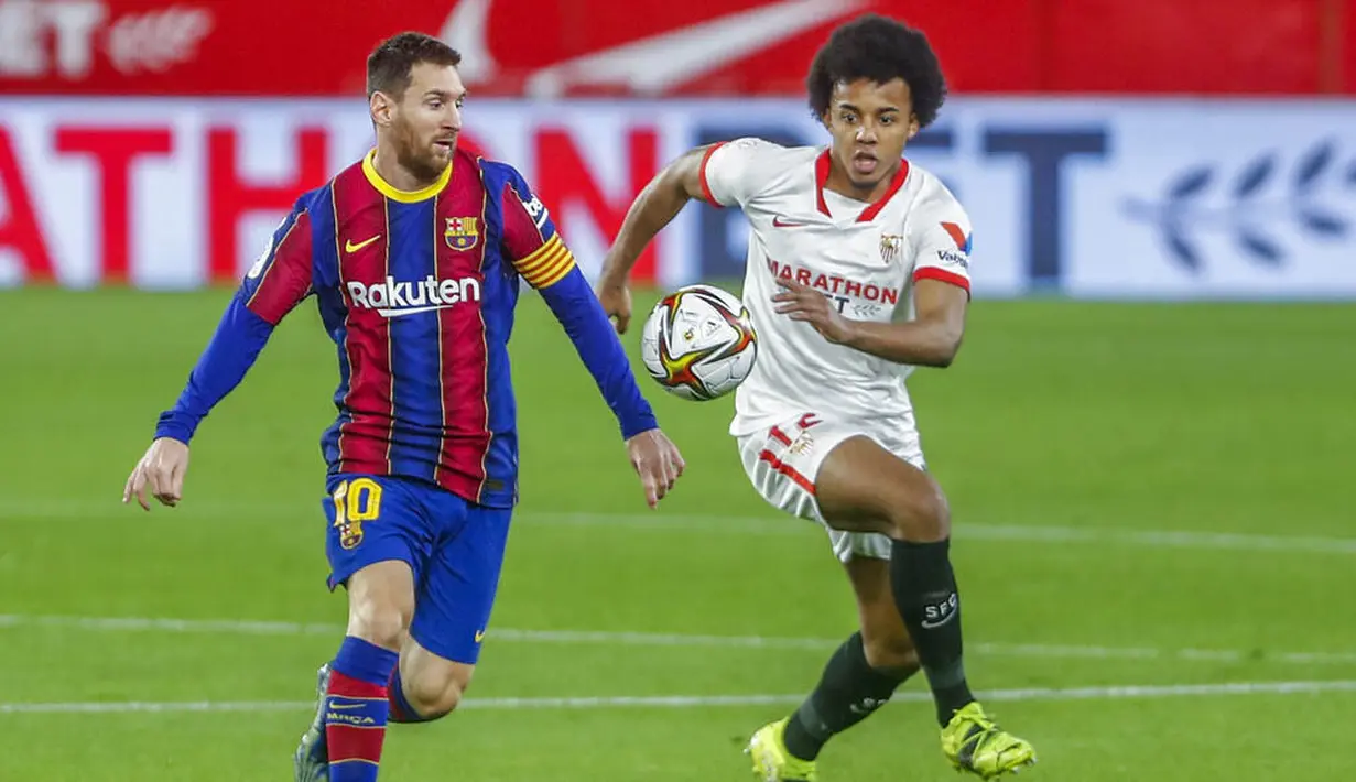 Striker Barcelona, Lionel Messi, berebut bola dengan pemain Sevilla, Jules Kounde, pada laga leg pertama semifinal Copa del Rey di Estadio Ramon Sanchez Pizjuan, Kamis (11/2/2021). Barcelona tumbang dengan skor 2-0. (AP/Angel Fernandez)