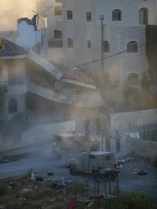 Tentara Israel memeriksa rumah warga Palestina Amerika Muntasser Shalaby usai diledakan di desa Turmus Ayya, Tepi Barat, utara Ramallah (8/7/2021). Operasi pembongkaran berlangsung sepanjang malam hingga pagi hari. (AP Photo/Nasser Nasser)