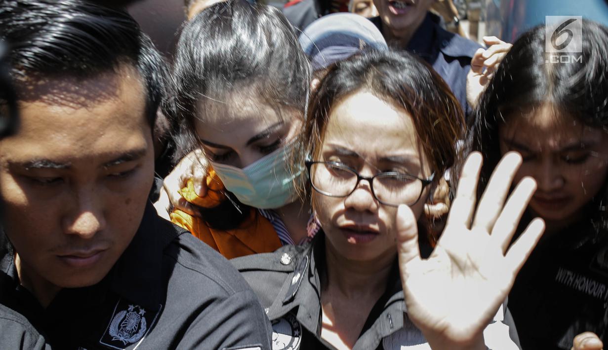 Artis dan tersangka kasus narkoba Jennfer Dunn dikawal ketat penyidik Polda Metro setibanya di Kejaksaan Negeri Jakarta Selatan, Kamis (15/3). Jennifer yang mengenakan baju tahanan berwarna oranye langsung dibawa menuju sel. (Liputan6.com/Faizal Fanani)