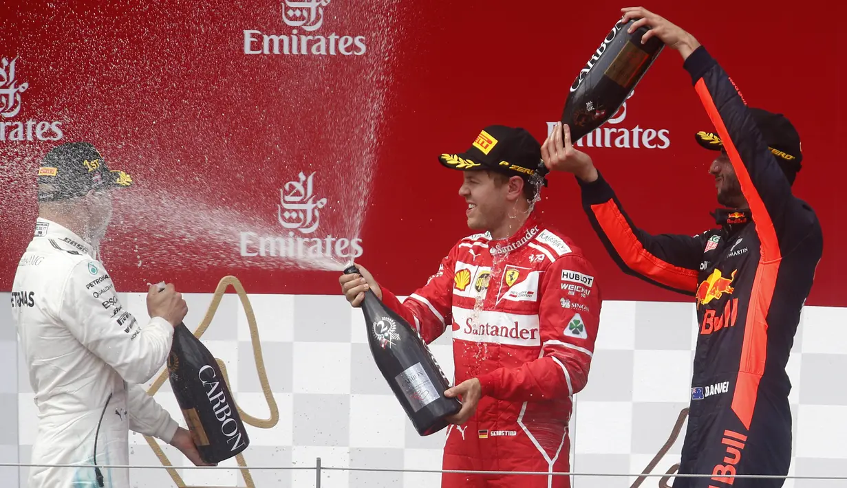 Pebalap Mercedes, Valtteri Bottas, pebalap Ferari, Sebastian Vettel dan pebalap Red Bull, Daniel Ricciardo melakukan selebrasi di atas podium. Valtteri Bottas menjadi yang tercepat dengan catatan waktu 1 jam 21 menit 48,527 detik. (AP/Darko Bandic)