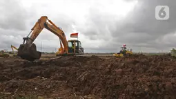 Petugas dari Dinas Bina Marga Pekerja menggunakan alat berat saat penggarapan lahan untuk dijadikan lokasi pemakaman khusus Covid-19 di Rorotan, Jakarta Utara, Selasa (5/1/2021). Pemprov DKI menyiapkan 1.500 lubang makam khusus COVID-19 di TPU Rorotan. (Liputan6.com/Herman Zakharia)
