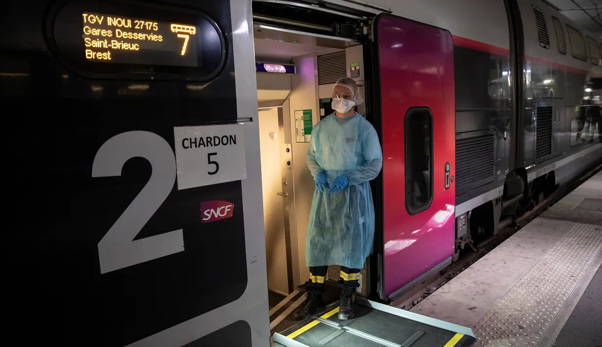 Petugas medis berdiri di pintu masuk kereta kecepatan tinggi TGV di Stasiun Gare d'Austerlitz di Paris, Prancis, Rabu (1/4/2020). Prancis mengerahkan kereta kecepatan tinggi untuk mengevakuasi pasien virus corona COVID-19 dari Paris ke wilayah Brittany. (Thomas SAMSON/AFP/POOL)