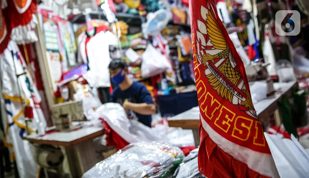 Aktivitas penjahit bendera merah putih di kiosnya, kawasan Pasar Senen, Jakarta, Rabu (5/8/2020). Menjelang peringatan HUT ke-75 Kemerdekaan RI, sejumlah pedagang mengaku penjualan pernak-pernik bendera merah putih menurun 50 persen dibanding tahun lalu akibat COVID-19. (Liputan6.com/Faizal Fanani)