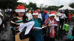 Jemaat GKI Yasmin Bogor dan HKBP Filadelfia Bekasi saat misa perayaan Natal 2016 di Silang Barat Laut Monas, Jakarta, Minggu (25/12). Ibadah di depan Istana Merdeka sudah mereka lakukan sejak Februari 2012. (Liputan6.com/Helmi Fithriansyah)