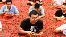 Sejumlah kontestan memakan cabai saat mengambil bagian dalam kompetisi makan cabai di Ningxiang di provinsi Hunan tengah, China (8/7). Pemenang dalam kontes ini telah memakan 5 cabai dalam waktu satu menit. (AFP Photo)