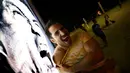 Salah satu pengunjung pantai Copacabana, Rio de Janeiro, Brasil, (26/6/2014), berekspresi di depan iklan bergambar Luis Suarez. (REUTERS/Kai Pfaffenbach)