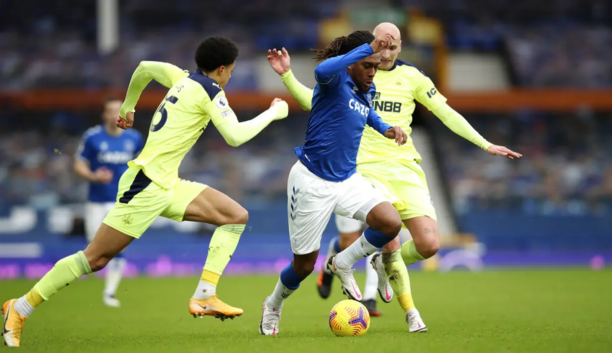 Pemain Everton Alex Iwobi (tengah) membawa bola melewati pemain Newcastle United Jamal Lewis dan Jonjo Shelvey pada pertandingan Liga Inggris di Goodison Park, Liverpool, Inggris, Sabtu (30/1/2021). Newcastle United menang 2-0. (Clive Brunskill/Pool via AP)