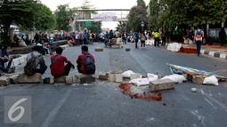 Mahasiswa membentuk blokade serta menutup jalan Diponegoro dengan meletakkan batu, Jakarta, Selasa (27/10/2015). Mereka menuntut rektor UPI YAI mundur dari jabatannya karena menutupi skandal penipuan terhadap 1.080 mahasiswa. (Liputan6.com/Yoppy Renato)