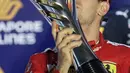 Pembalap Ferrari Sebastian Vettel berselebrasi di podium setelah memenangkan balapan Formula Satu (F1) Grand Prix Singapura di Sirkuit Jalan Marina Bay, Singapura (22/9/2019). Vettel berhasil menjuarai balapan dengan catatan waktu 1 jam:58menit:33.667 detik. (AP Photo/Vincent Thian)