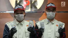 Petugas KPK menunjukkan barang bukti hasil OTT Bupati Muara Enim uang 35.000 dollar AS di Gedung KPK, Jakarta, Selasa (3/9/2019). KPK menahan 4 tersangka terkait suap 6 proyek peningkatan pembangunan jalan di Muara Enim. (merdeka.com/Dwi Narwoko)