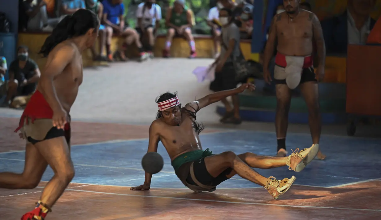 Pria pribumi bermain dalam final turnamen bola Maya di San Juan La Laguna, Solola, Guatemala, pada 18 September 2021. Sebanyak 12 tim, termasuk satu perempuan, berpartisipasi untuk mengklasifikasikan turnamen Mesoamerika yang akan diadakan di Meksiko pada Desember 2021. (Johan ORDONEZ/AFP)