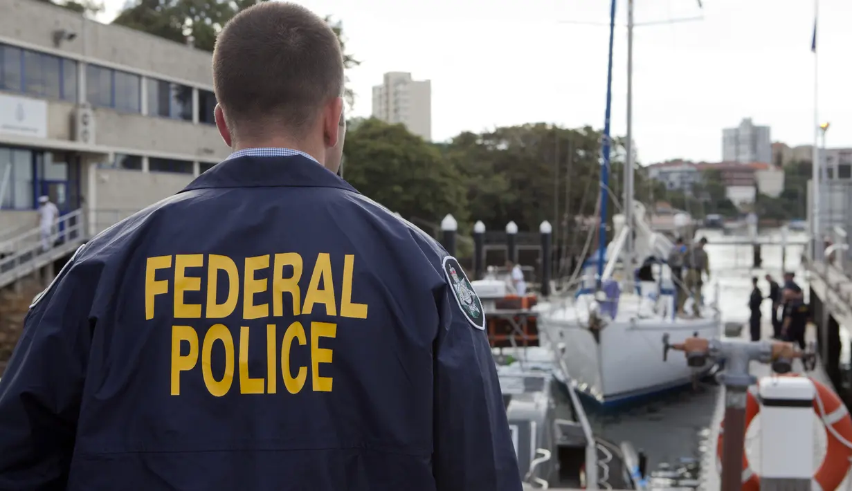 Polisi federal Australia mengawasi sebuah yacht yang membawa 1,4 ton kokain di Sydney, Senin (6/2). Kokain senilai US$ 312 juta (setara Rp 4,1 triliun) itu disita dari yacht Elakha di South Coast, New South Wales. (STR/Australian Federal Police/AFP)