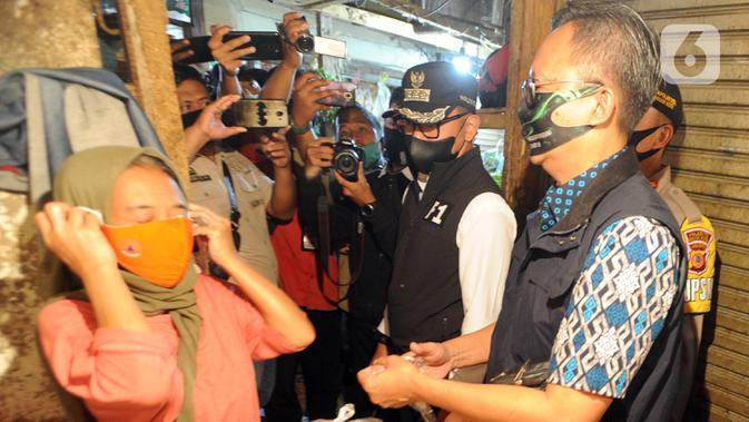 Wali Kota Bogor Bima Arya (tengah) saat mengecek kepatuhan warga dalam menggunakan masker di Pasar Ciawi, Bogor, Kamis (10/9/2020). Kegiatan ini bagian dari kesepakatan antara Pemkot dan Pemkab Bogor dalam pengawasan penerapan protokol kesehatan di titik-titik perbatasan. (merdeka.com/Arie Basuki)