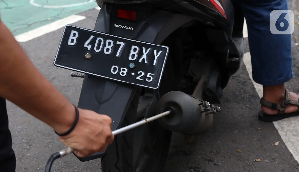 Petugas memeriksa emisi motor di Jakarta Barat, Rabu (13/1/2021). Dinas Lingkungan Hidup DKI Jakarta mengumumkan kendaraan yang tidak mengikuti uji emisi atau tidak lulus uji emisi gas buang akan dikenakan disinsentif tarif parkir yang tinggi dan tilang. (Liputan6.com/Angga Yuniar)