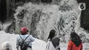 Wisatawan berfoto-foto saat mengunjungi Curug Parigi, Cikuwul, Bantargebang, Bekasi, Jawa Barat, Minggu (19/7/2020). (merdeka.com/Iqbal S. Nugroho)