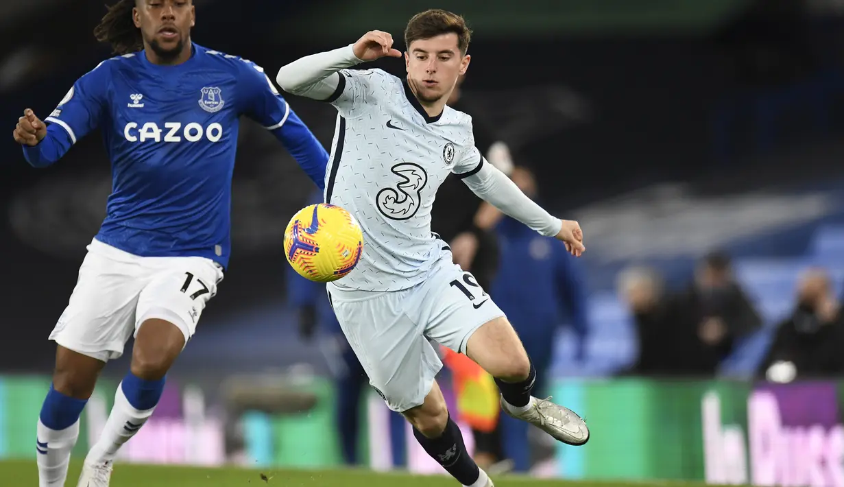Gelandang Everton, Alex Iwobi berebut bola dengan gelandang Chelsea, Mason Mount pada pertandingan lanjutan Liga Inggris di Goodison Park di Liverpool, Inggris, Minggu (13/12/2020). Everton menang tipis atas Chelsea 1-0. (Peter Powell/Pool via AP)