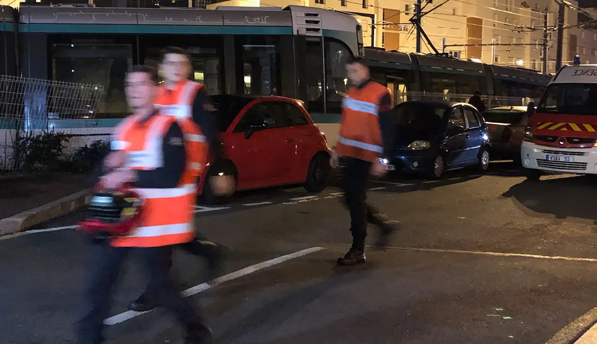 Personel layanan darurat berkumpul di lokasi tabrakan antara dua rangkaian trem di wilayah Issy-les-Moulineaux, Paris, Senin (11/2). Insiden seperti ini tergolong langka terjadi di jaringan trem pinggiran Paris yang selalu sibuk. (Philippe DUPEYRAT / AFP)
