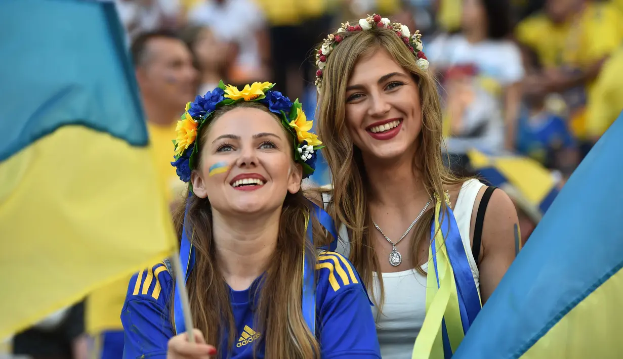 Dua Suporter cantik Ukraina terlihat bersemangat mendukung timnya berlaga melawan Polandia pada Euro 2016 di Stadion Velodrome, Marseille, Rabu (22/6/2016) dini hari WIB. (AFP/Bertrand Langlois)